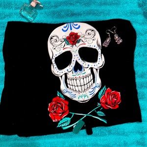 A plain black shirt with a skull on the front with roses. 11-13 in women’s ,,
